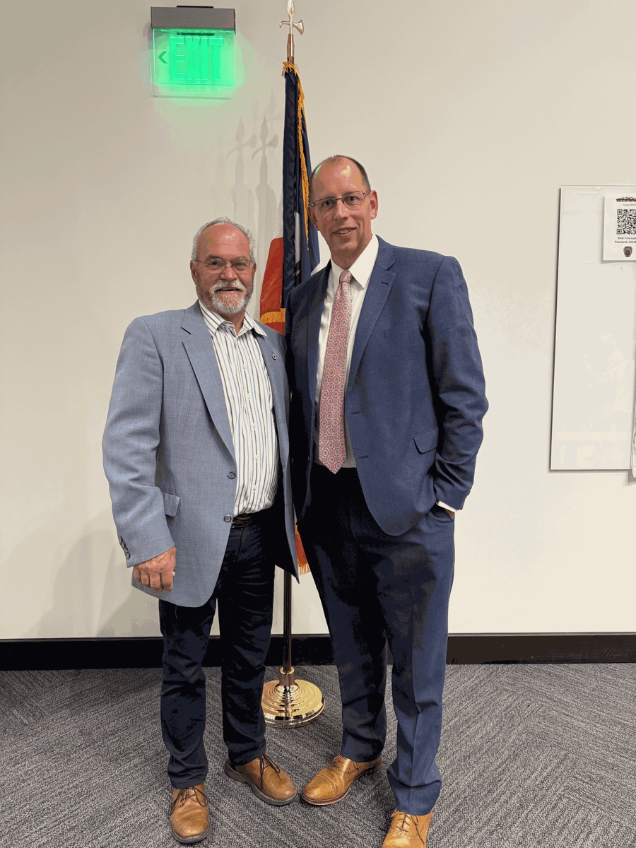 Senator Ron Winterton and Jeremy Hales standing together in front of the Utah state flag